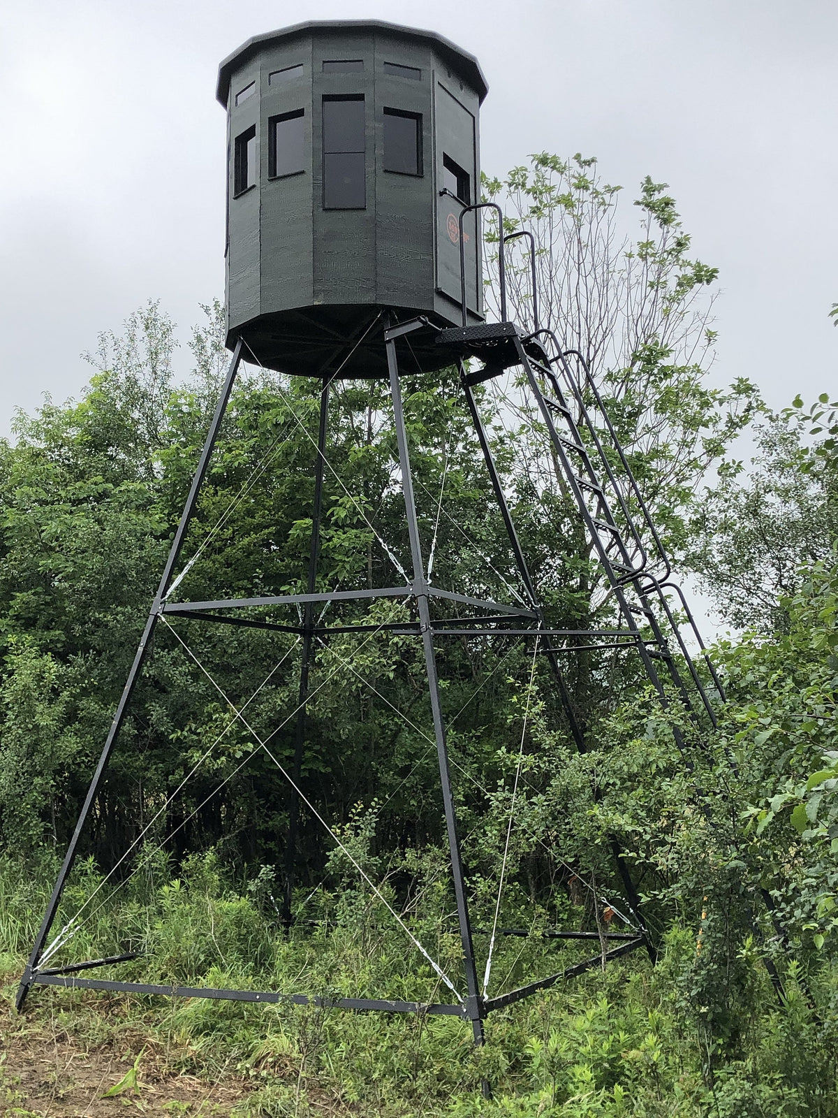 360 Pro XL hunting blind on a tall tower stand surrounded by green trees and brush