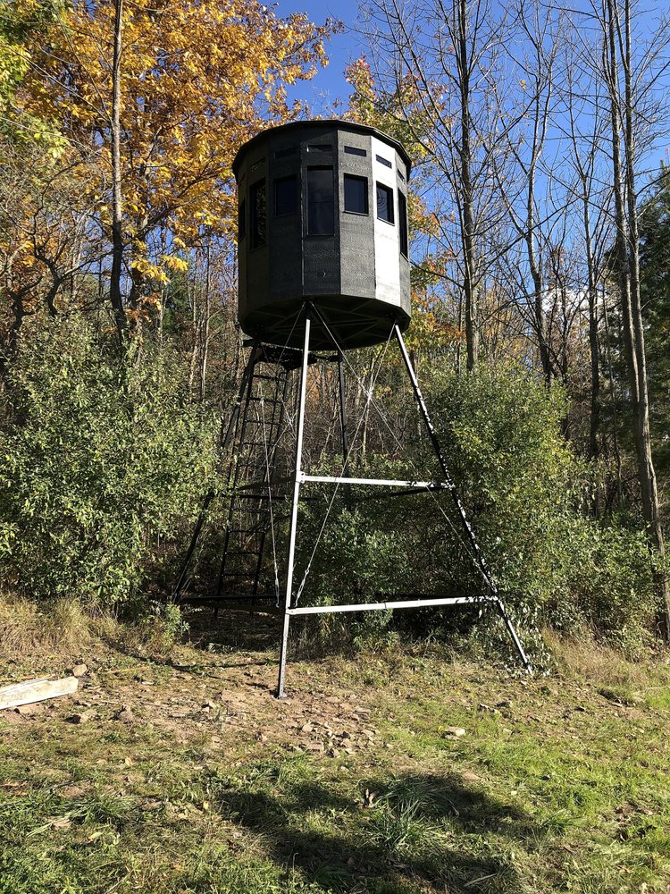 360 Pro hunting blind elevated on a tower stand among autumn trees