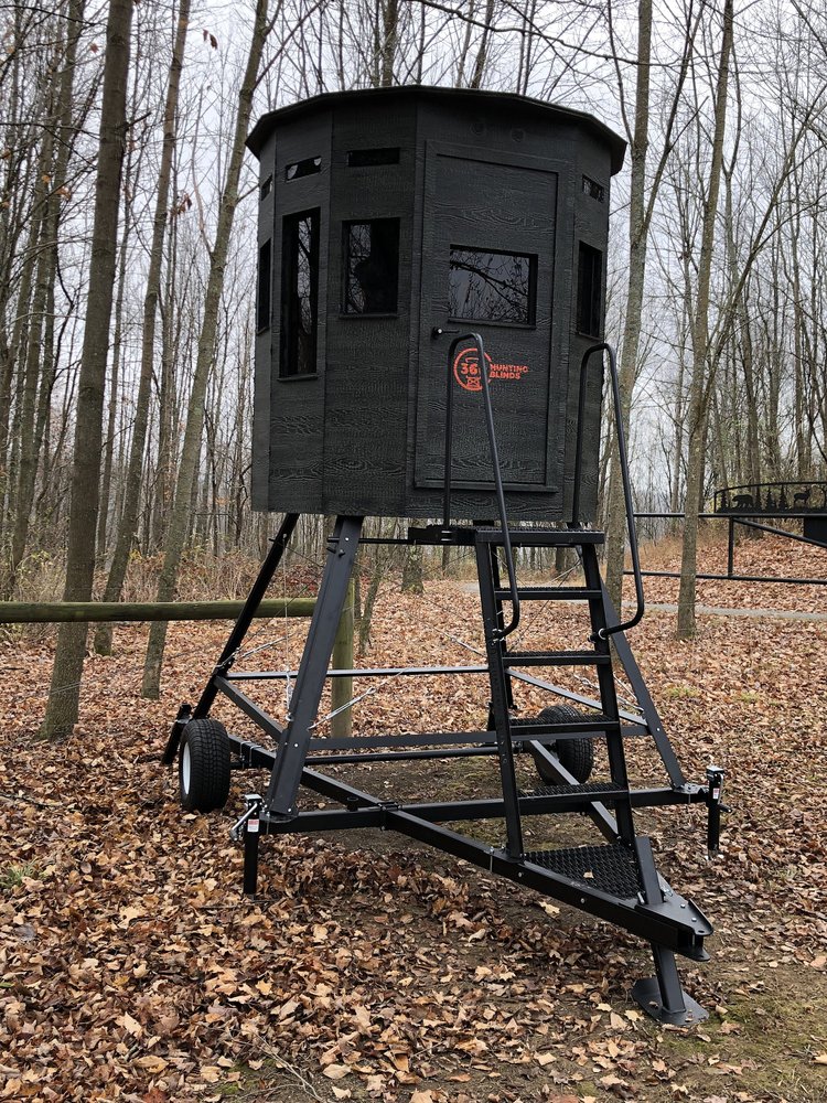 360 Pro hunting blind on a tower stand mounted to the trailer system, set among bare autumn trees for a mobile blind setup